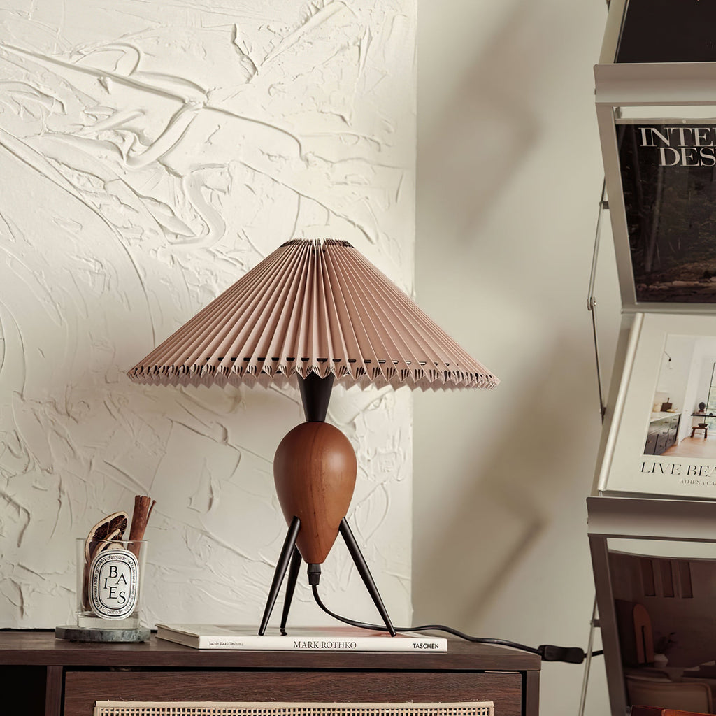 On a dark wood console against textured plaster, this Clérachic table lamp stands near magazines and a small candle.