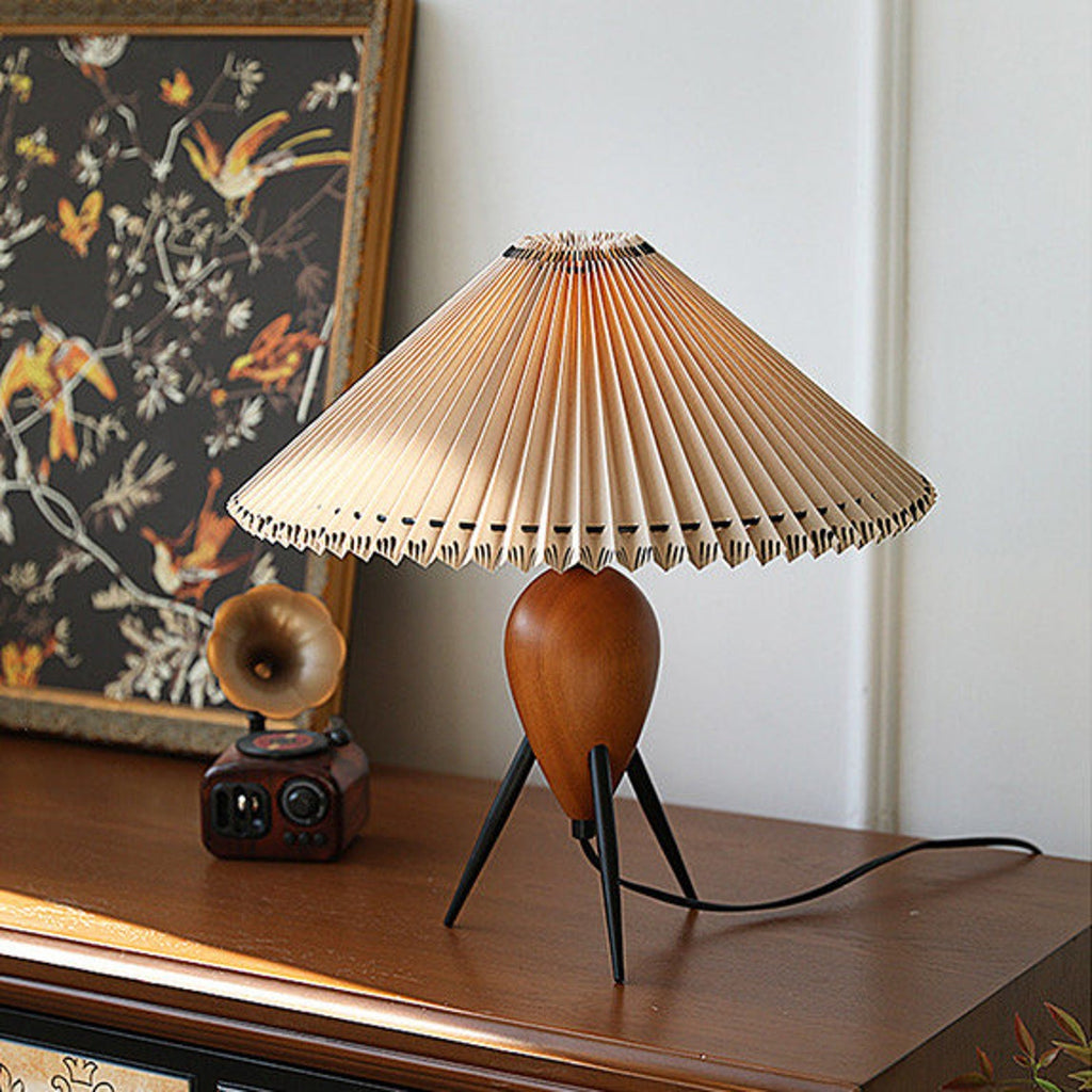 This Clérachic table lamp, unlit, stands by a bird-print panel and a vintage radio on a dark wood cabinet.
