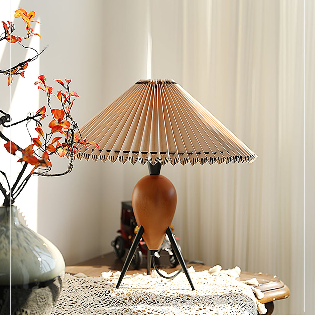 This Clérachic table lamp sits by a window with orange autumn sprigs and a lace runner, soft curtains behind.