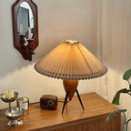 On a wooden sideboard, this Clérachic table lamp stands beside a small radio and silver dessert bowls under a wall mirror.