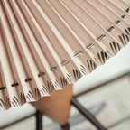 Close view of the metal staples and hand-finished pleat edge on the shade of this Clérachic table lamp.