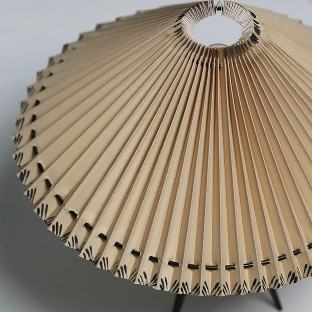 Looking up into this Clérachic table lamp's shade, the pleats fan out from the centre ring to a stitched edge.