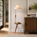 Beige-shaded Clérachic floor lamp with a small wood tray table, in a bright hallway beside a fluted wooden sideboard.