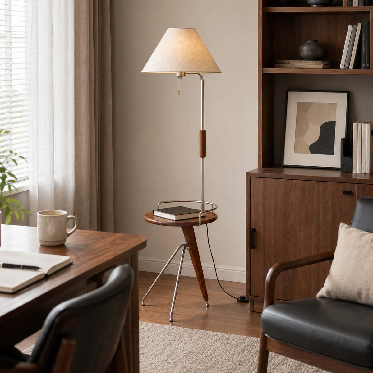 Clérachic floor lamp with a tray holding a book, between a wooden desk and a dark leather armchair near shelves.