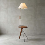A Clérachic floor lamp with a beige shade and walnut tray table on a polished concrete floor against a grey wall.