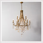 The Clérachic Trove chandelier in brass, tiered arms lit above a cascade of natural alabaster and crystal drops.