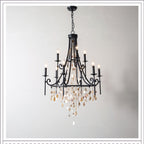 Clérachic Trove in black against a pale wall, chain suspension and canopy visible above the tapered frame.