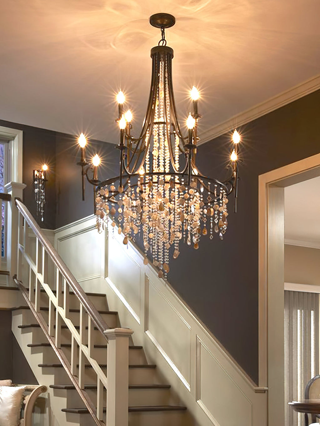 Clérachic Trove lit above a staircase, its candle lamps glowing against a deep navy stairwell wall.