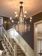 Clérachic Trove lit above a staircase, its candle lamps glowing against a deep navy stairwell wall.