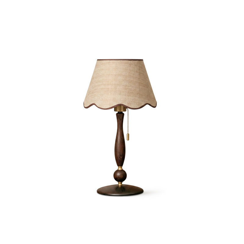 Side-angle studio view of the shade, turned walnut stem, brass collar and round base, on a white backdrop; a Clérachic table lamp.