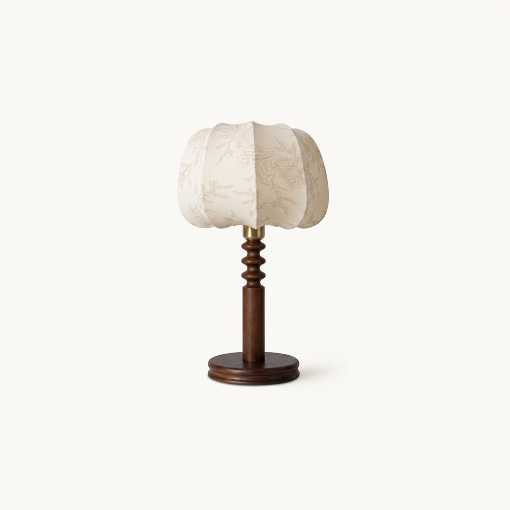 Clérachic table lamp on a plain white backdrop, a pleated beige fabric shade above a turned walnut-tone wood stem and round base.