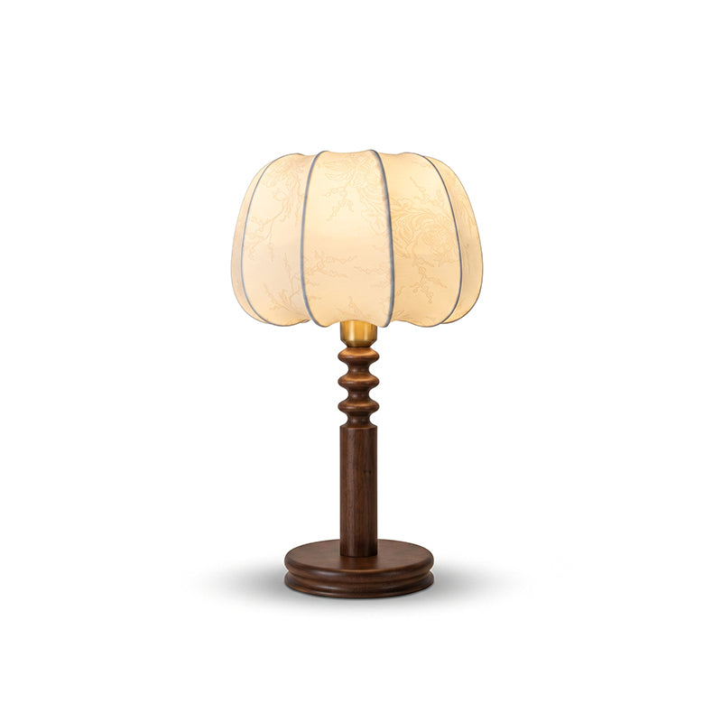 Cut-out view of this Clérachic table lamp, its pleated beige shade glowing above a turned walnut-tone stem and round base.