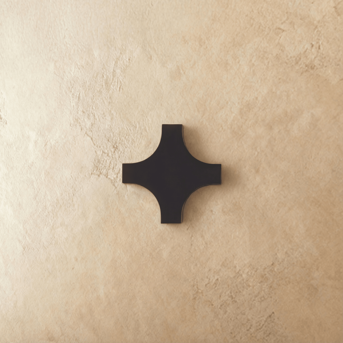 This cross-shaped Clérachic outdoor wall light in matte black aluminium sits flush against a plastered wall, unlit.