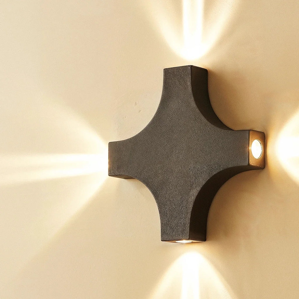 A closer angle on the Clérachic outdoor wall light shows its cross-shaped aluminium body directing four beams outward.