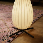 Clérachic close-up of the lit lower shade resting on its black four-legged base over a pink rug and oak floor.