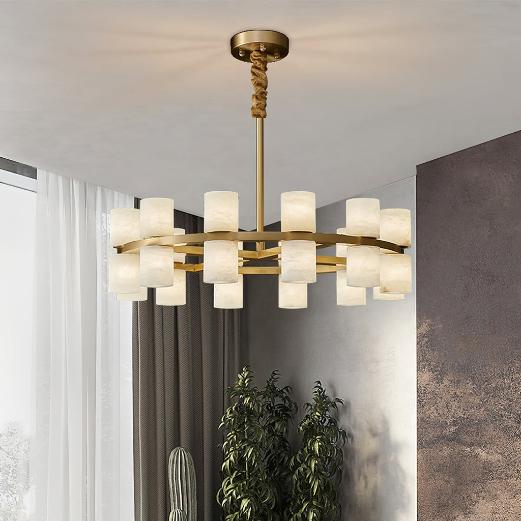 The Clérachic Two-Ring Chandelier lit in a bright corner room beside sheer curtains and a tall green plant.