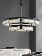 Clérachic Two-Tier Alabaster Ring Chandelier glowing warm over a tiled console table against a grey wall.
