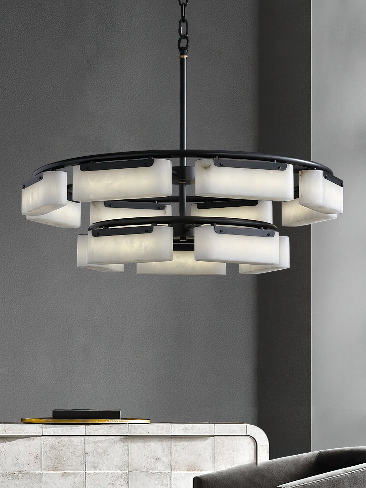 Clérachic Two-Tier Alabaster Ring Chandelier glowing warm over a tiled console table against a grey wall.