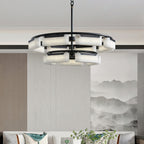 The Clérachic alabaster ring chandelier lit above a living-room sofa, its stone shades warm against an ink-wash mountain mural.