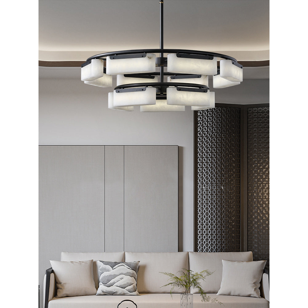 Clérachic alabaster ring chandelier lit in a living room, glowing above a linen sofa beside a dark latticed screen.