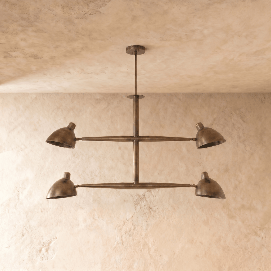 Clérachic chandelier in vintage brass shown from another angle, its crossbar arms catching warm light.
