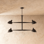 Clérachic chandelier in matte black shown from another angle, its crossbar arms catching soft light.