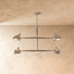 Clérachic chandelier in chrome, four cone shades on a crossbar frame beneath a plaster ceiling.