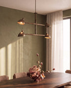 Clérachic chandelier in vintage brass glowing above a walnut table set with tulips and orchids.