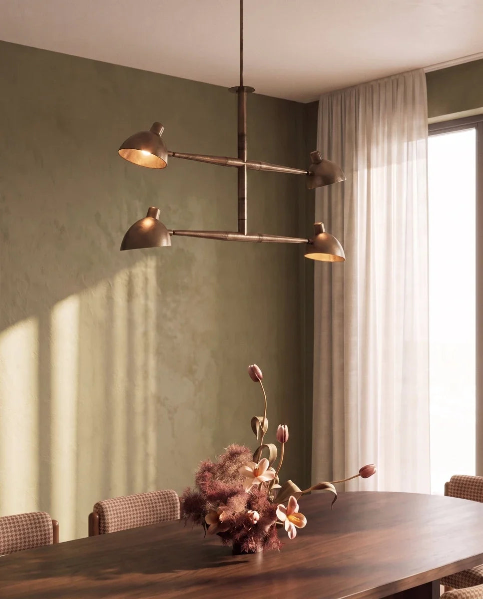 Clérachic chandelier in vintage brass glowing above a walnut table set with tulips and orchids.