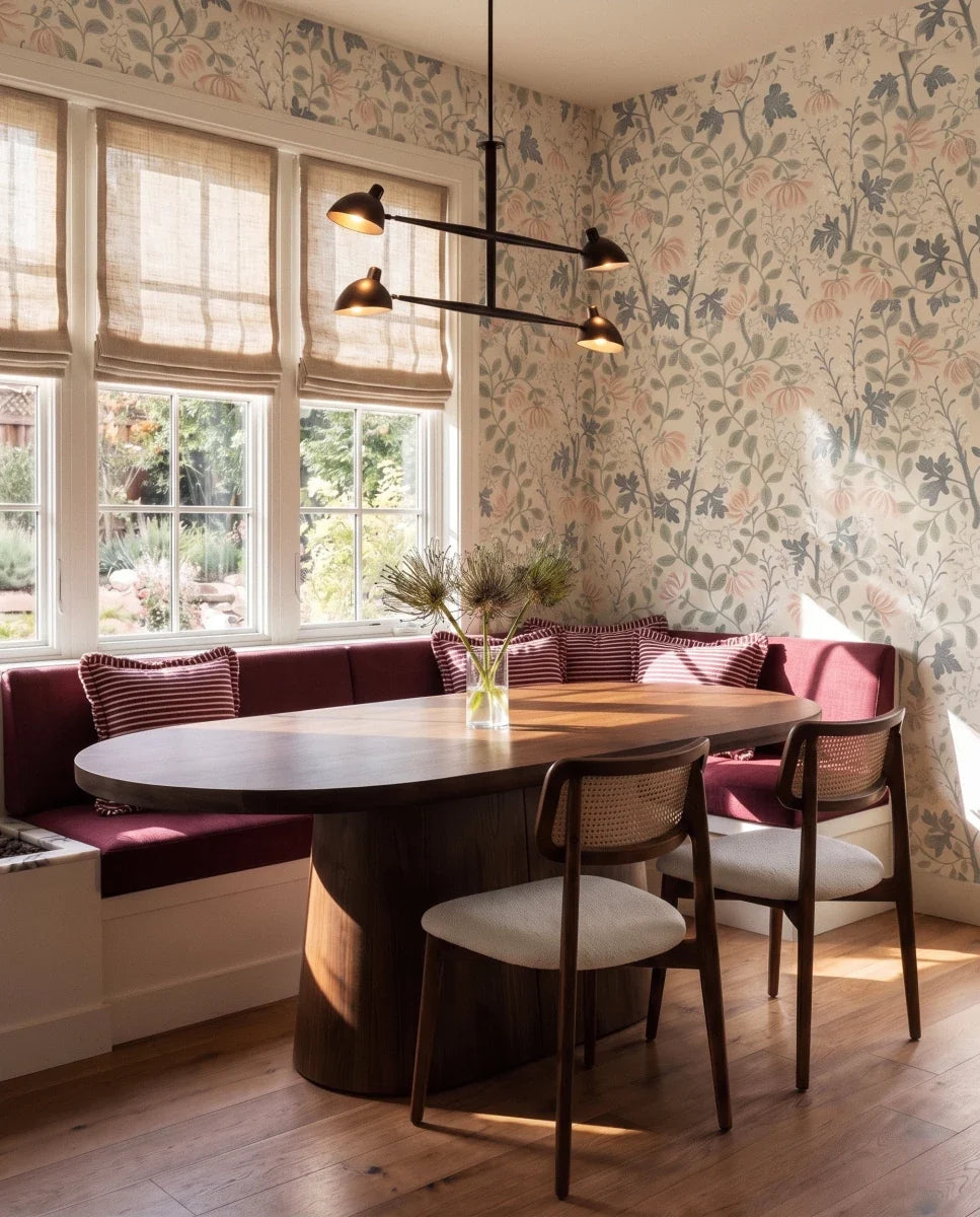 Clérachic chandelier in matte black above a burgundy banquette in a floral-wallpapered dining nook.