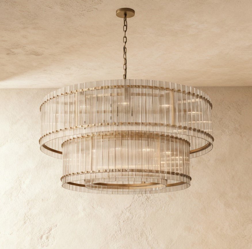 Clérachic largest two-tier chandelier in antiqued brass, fluted glass rods around a brass frame, against a limewash wall.