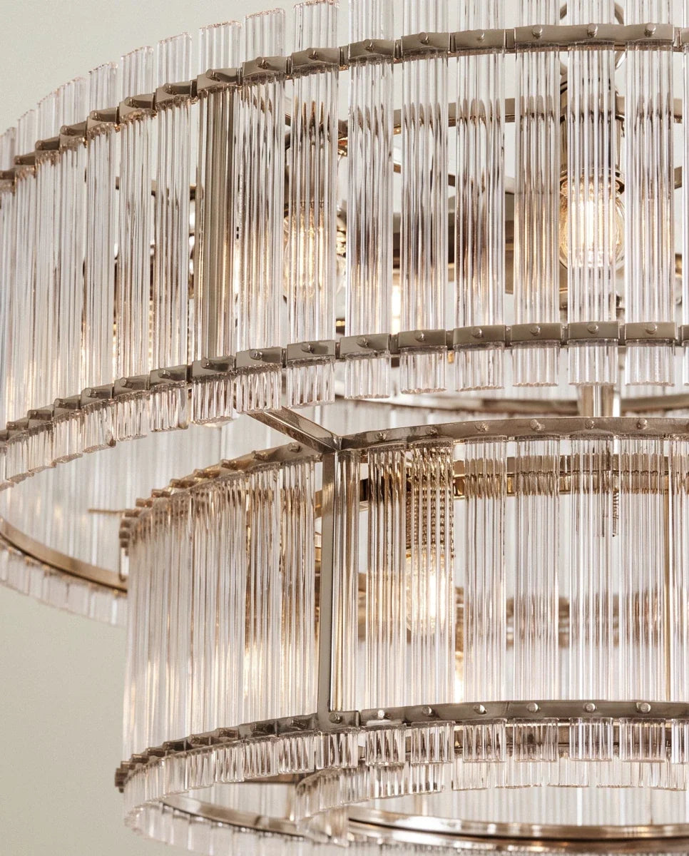 Clérachic close view of the polished nickel chandelier, showing riveted metal bands holding two tiers of fluted glass rods.