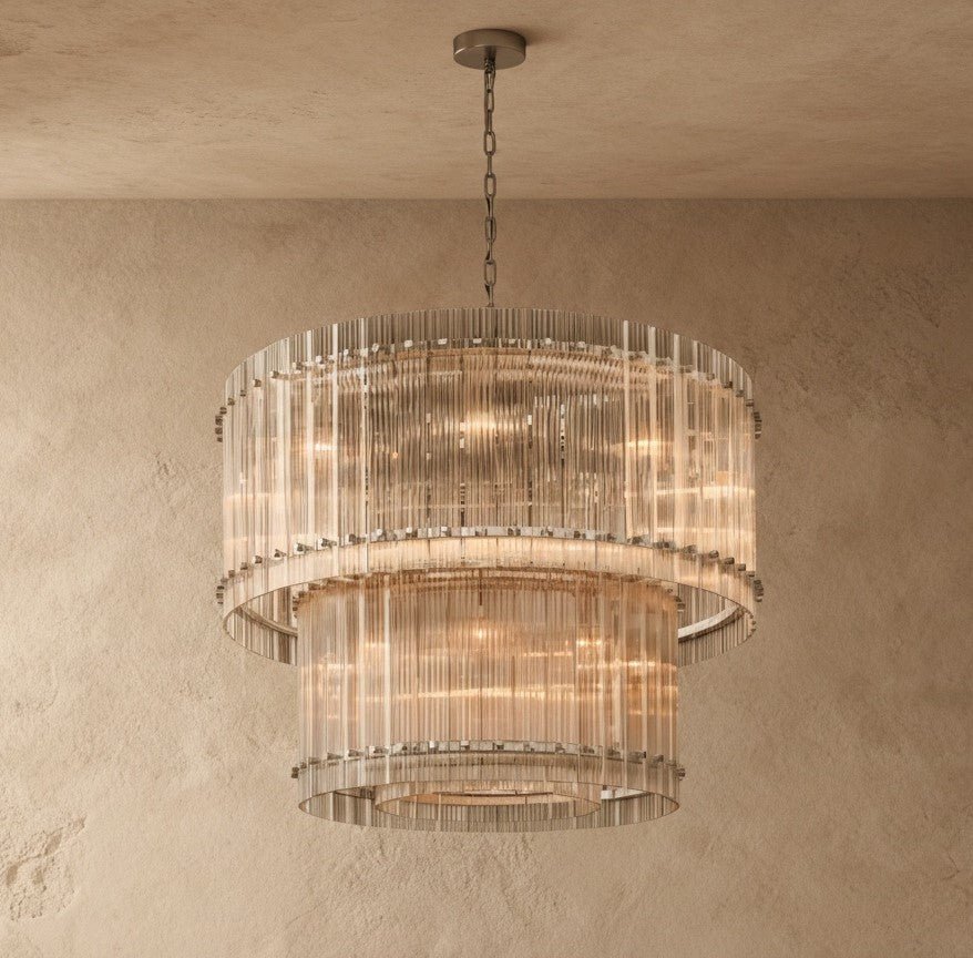 Clérachic two-tier chandelier with fluted clear glass rods and a pewter-toned canopy and chain, on a darker plaster wall.
