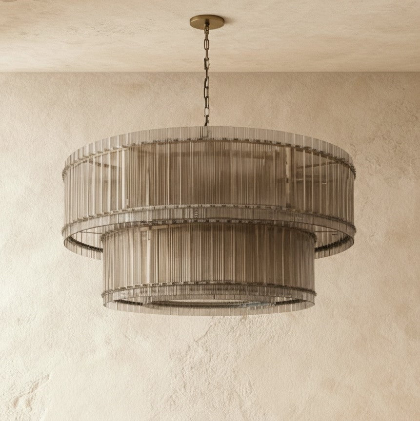 Clérachic large two-tier chandelier in a muted metal finish with smoky fluted glass rods, hung against limewash plaster.