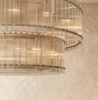 Clérachic close view of the lower edge of the two-tier chandelier, fluted clear glass rods catching warm light.