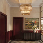 Clérachic antiqued brass two-tier chandelier hung in a panelled entrance hall with a patterned tile floor and a landscape painting.
