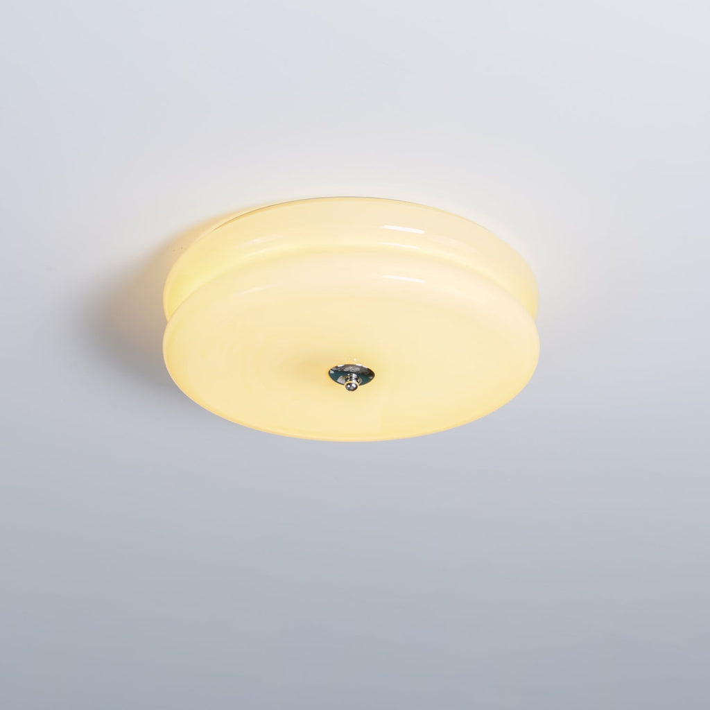 Cream glass Clérachic two-tier flush mount ceiling light lit against a pale grey ceiling, chrome finial below.