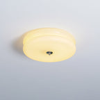 Cream glass Clérachic two-tier flush mount ceiling light lit against a pale grey ceiling, chrome finial below.