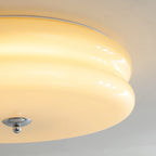 Extreme close-up of the Clérachic two-tier flush mount ceiling light, lit cream glass tiers and chrome finial.