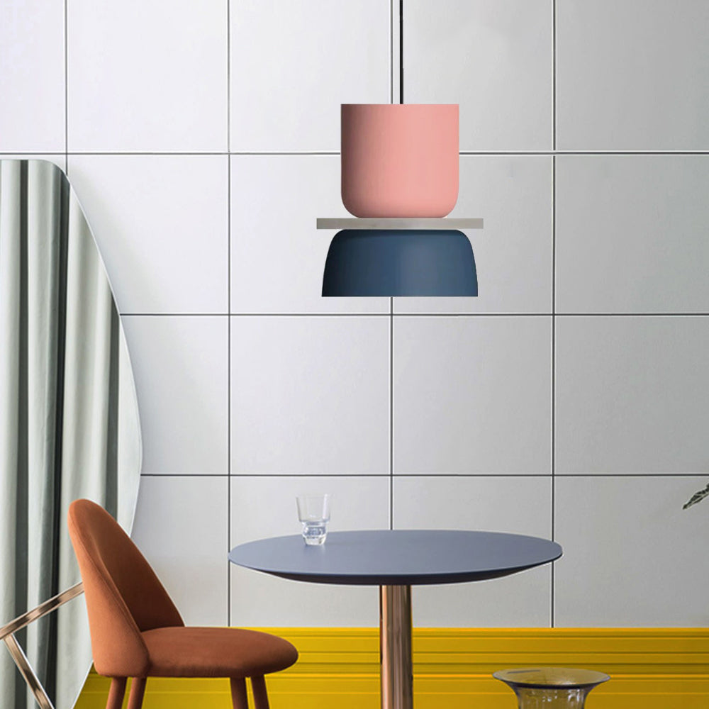 A Clérachic two-tone dome pendant in dusty pink and navy blue hangs beside a round table in a tiled kitchen.