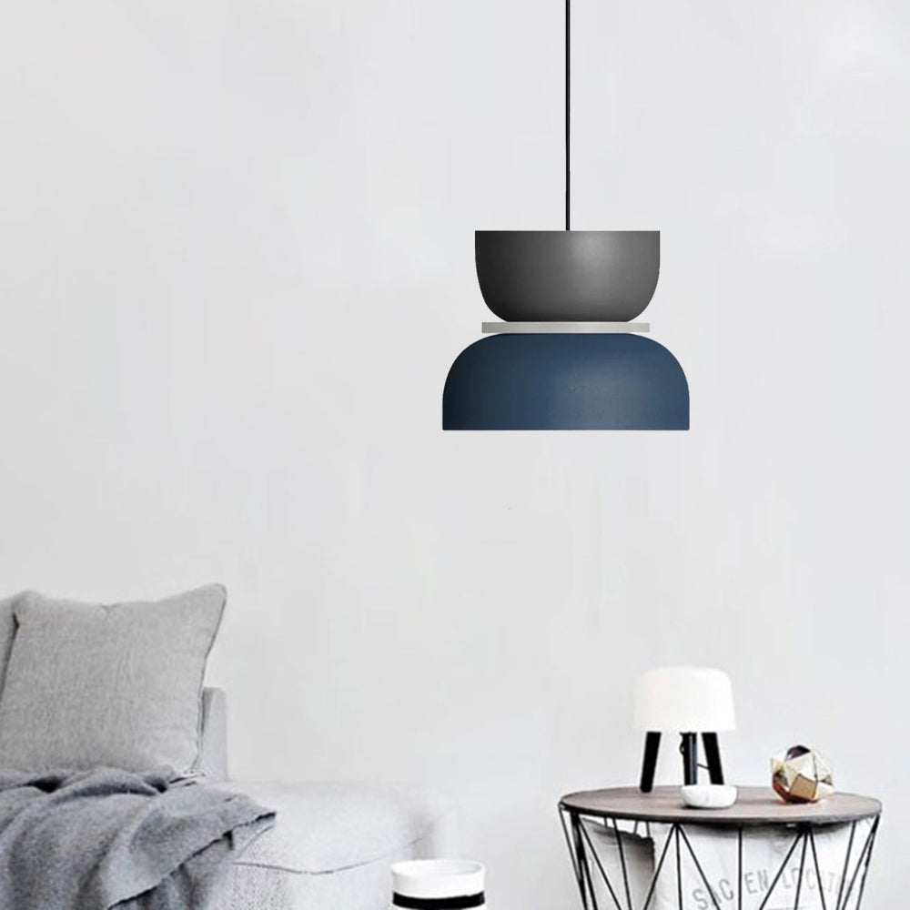 A Clérachic two-tone dome pendant in charcoal gray and navy blue hangs over a side table in a neutral living room.