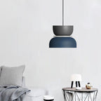 A Clérachic two-tone dome pendant in charcoal gray and navy blue hangs over a side table in a neutral living room.