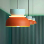 Three Clérachic two-tone dome pendants in pale blue and rust orange hang in a row against a ribbed teal wall.