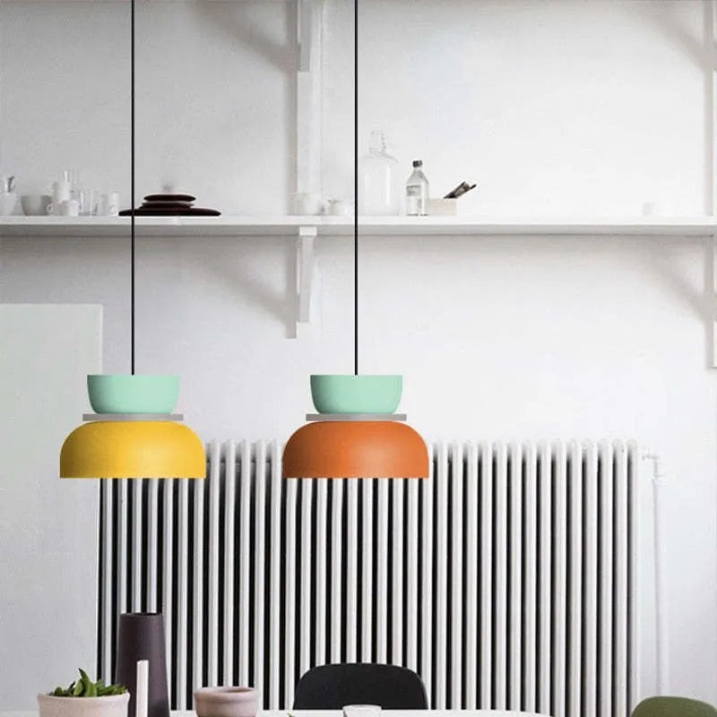Two Clérachic two-tone dome pendants in mint-yellow and mint-orange hang side by side above a kitchen radiator.