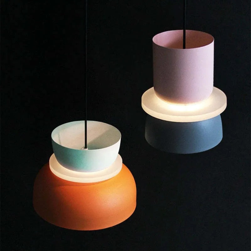 A Clérachic two-tone dome pendant tilted to show its lit diffuser ring and bulb holder inside the mint-orange shade.