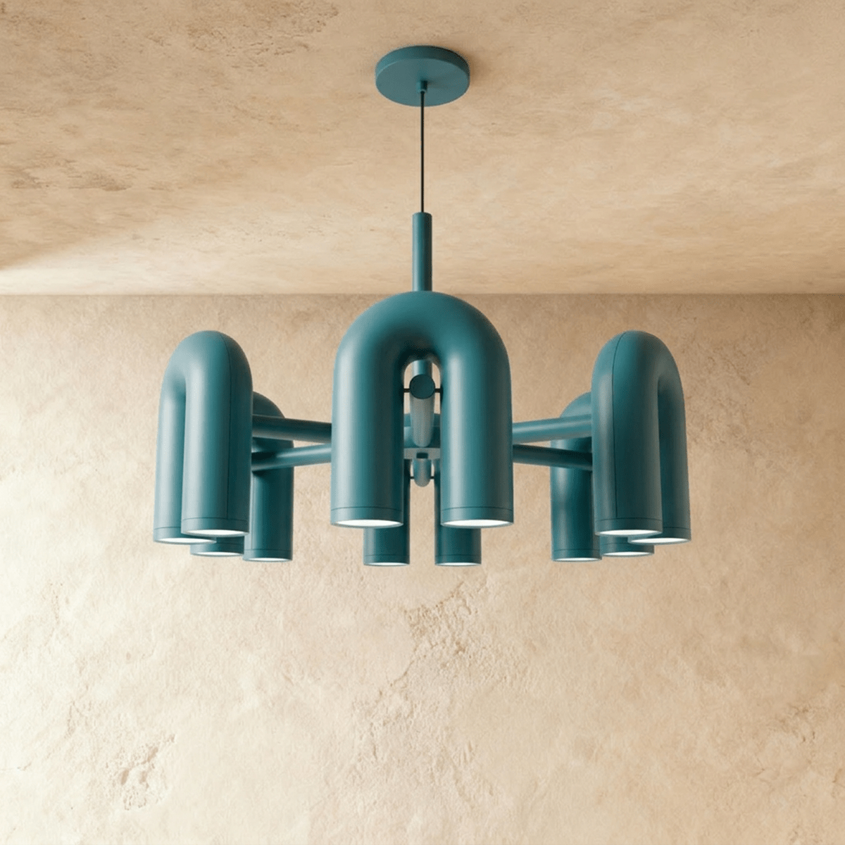 Clérachic larger chandelier with a fuller ring of blue U-shaped arch modules, hung on a cable against a plaster wall.