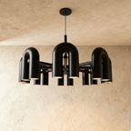 Clérachic widest chandelier in black, a full ring of U-shaped arch modules with downlights, hung from a round ceiling plate.