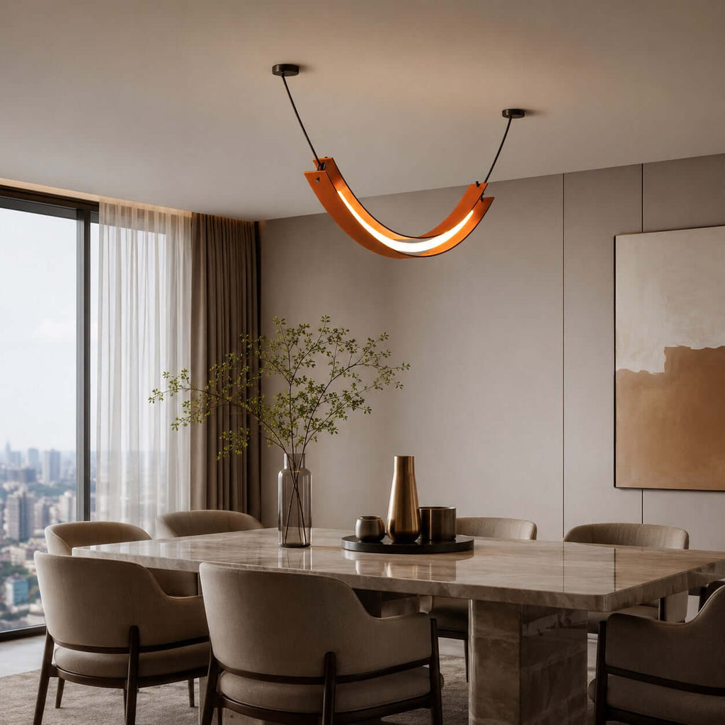 This Clérachic pendant, a terracotta U-shaped curve with a lit strip, hangs over a marble dining table in a high-rise dining room.