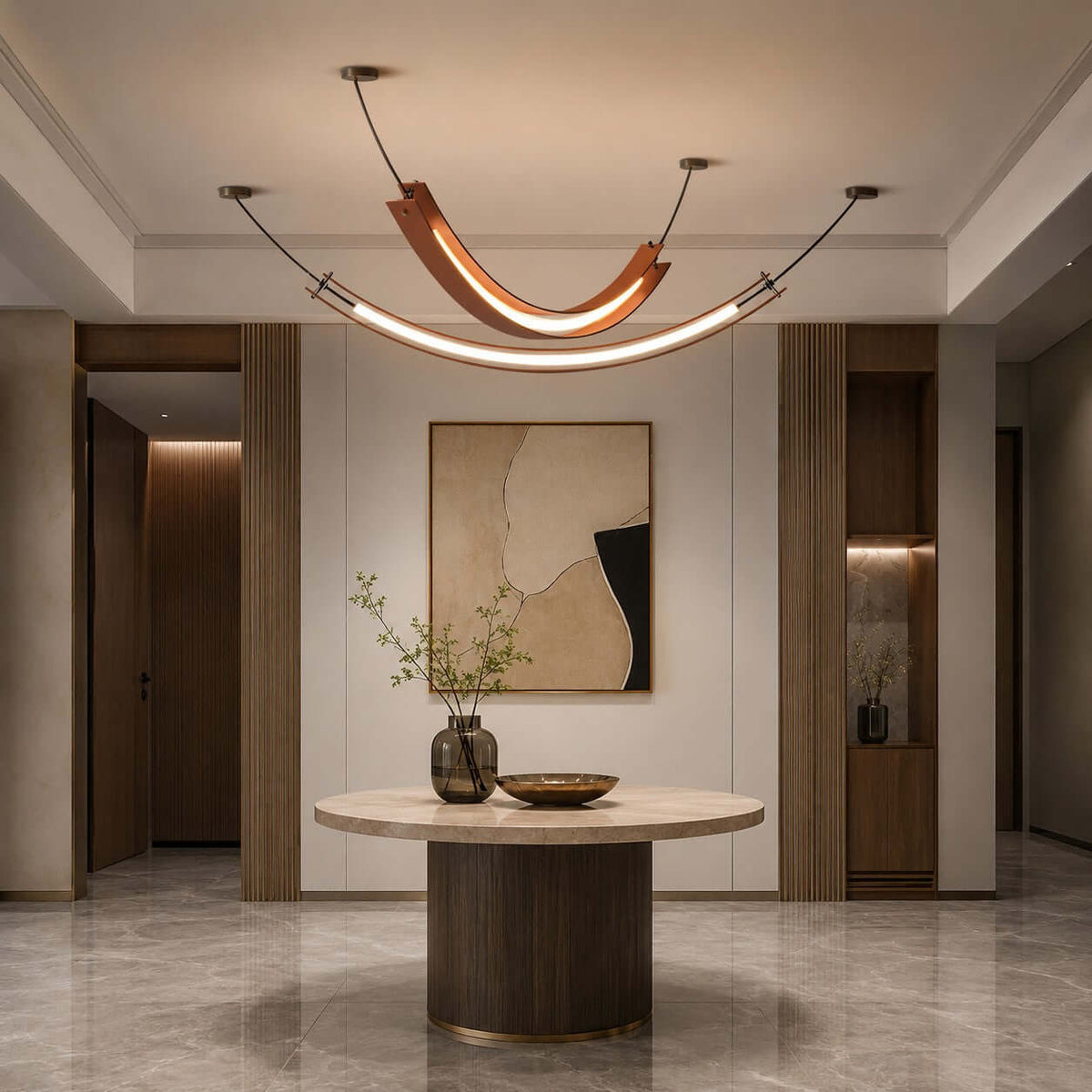 This Clérachic pendant with a lit U-shaped curve and a long strip below hangs in an entrance hall above a round pedestal table.