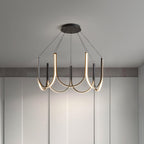 The Clérachic looped arm pendant lit above a pale room, warm light tracing each curve.